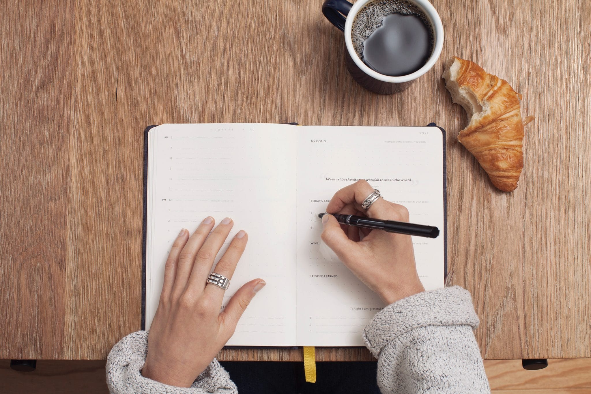 Time management tools. Woman writing her daily objectives in planner 