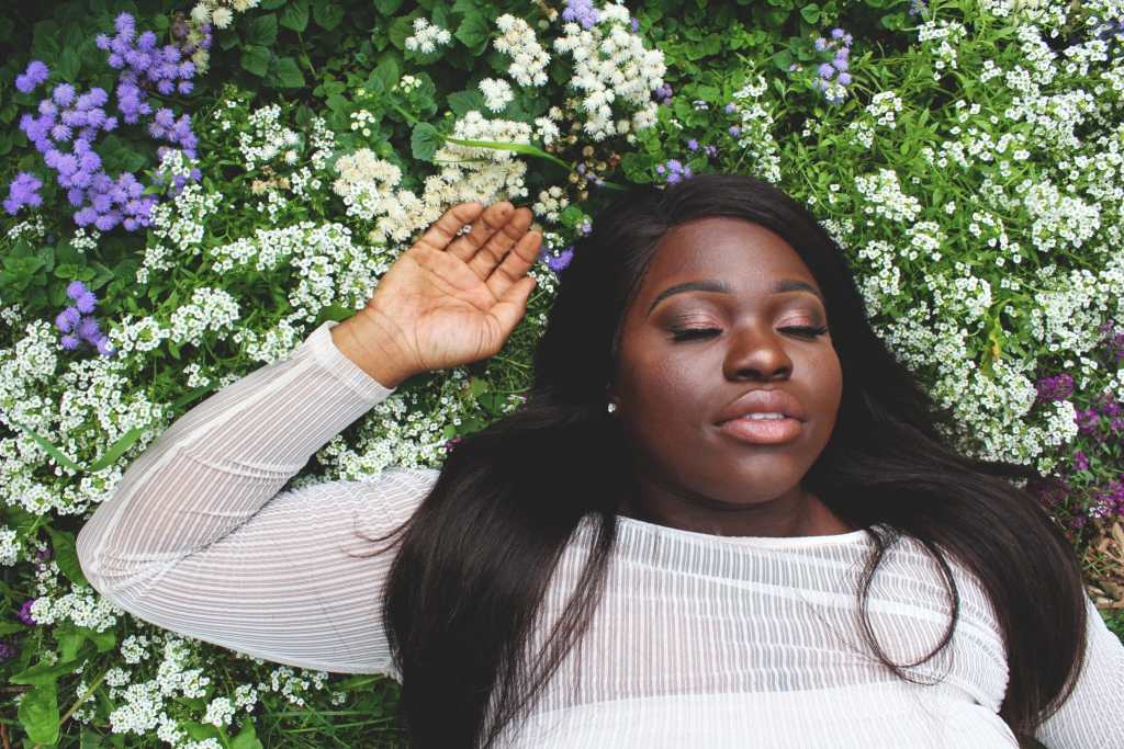 Women relaxing in flowers with the extra time gained from using a time tracker