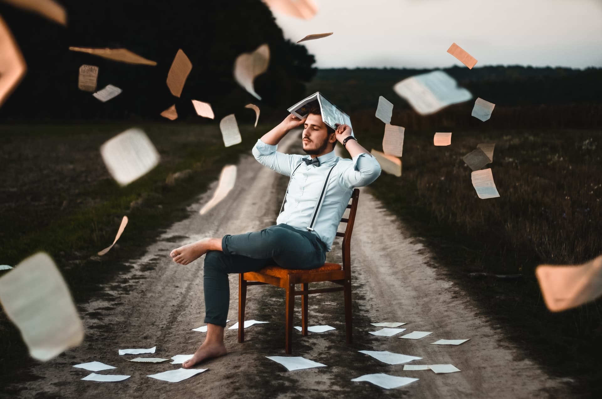 man overwhelmed with book pages everywhere