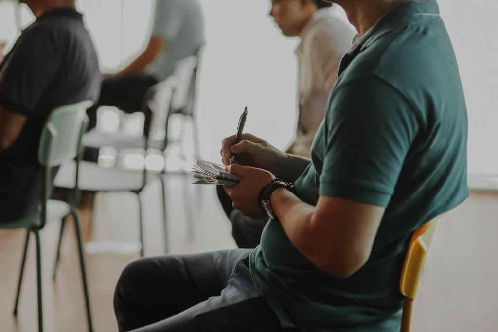 Male student taking notes by hand in class