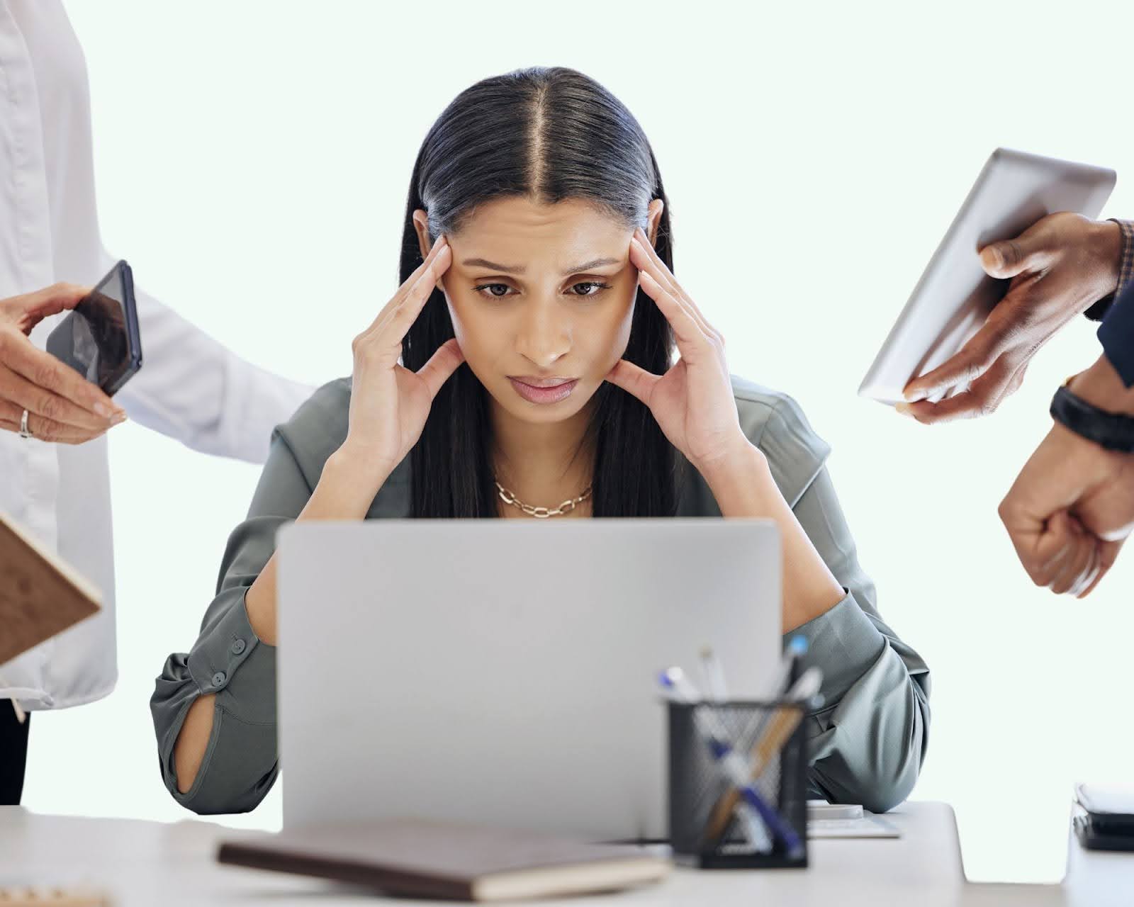 Woman overwhelmed by technology in a modern office.