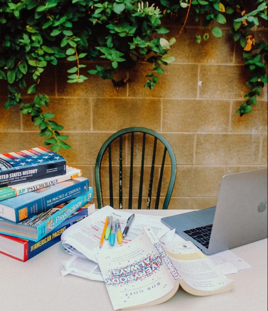 study tips - desk with textbooks, notes, and a laptop