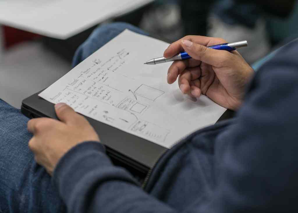 Man writing out his notes to condense and process the information