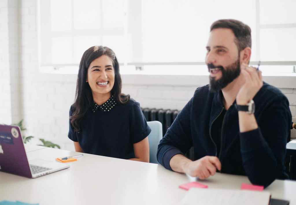 Two colleagues discussing and laughing