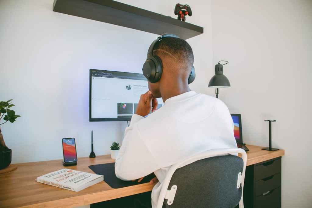 Man working on a computer with his headphones on