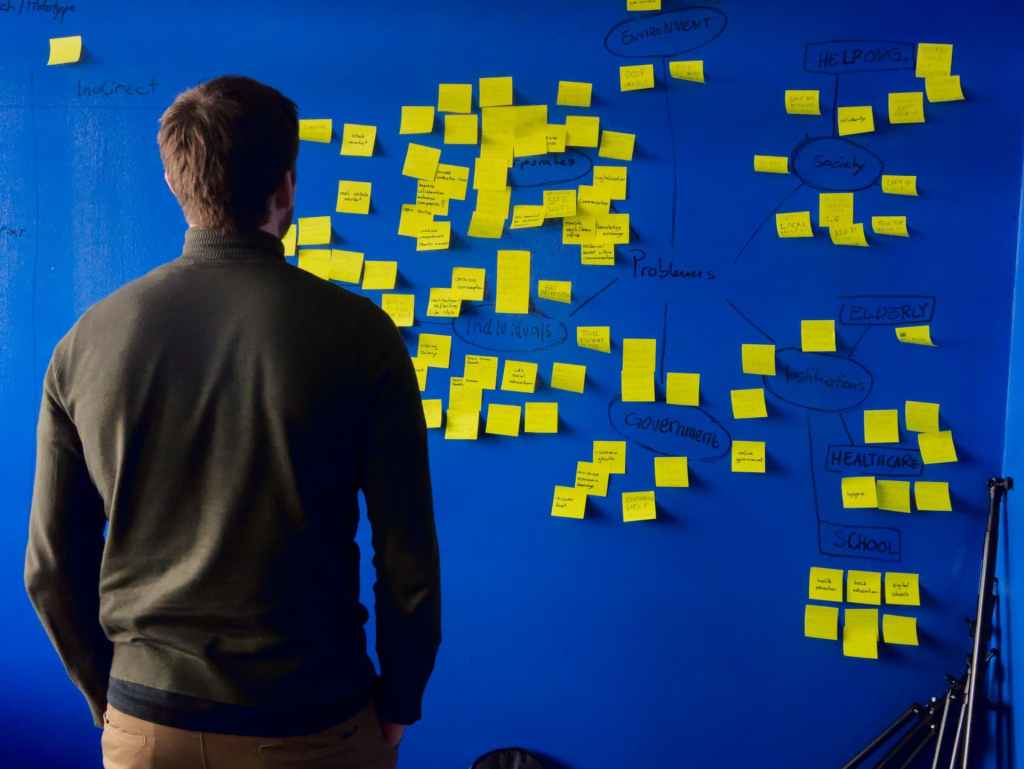 Man standing in front of brainstorming sticky notes