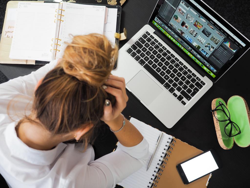 stressed woman working at messy desk