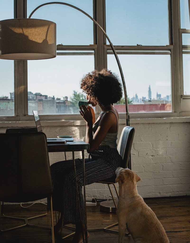 woman working with coffee while dog watches