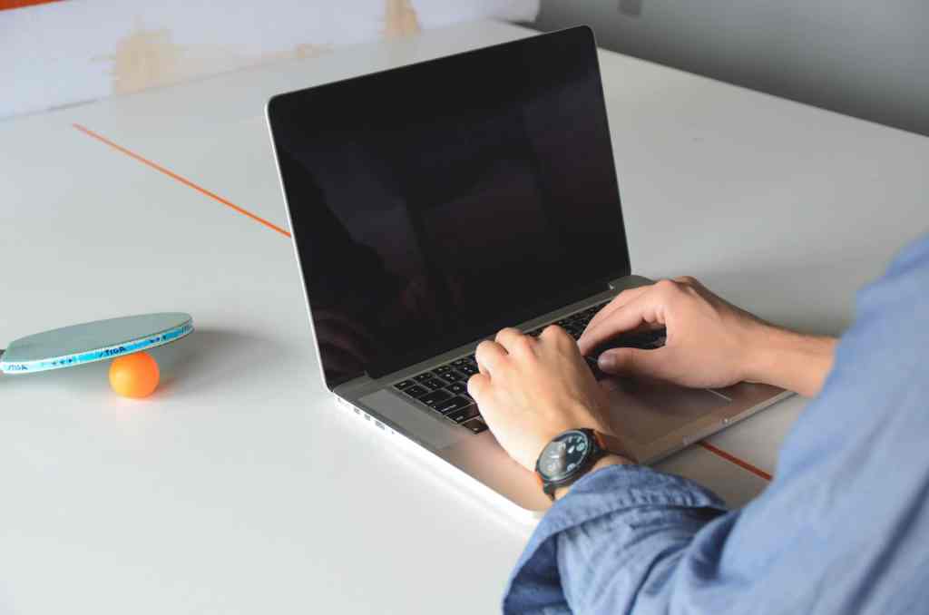 laptop and ping pong on desk of office worker more fun