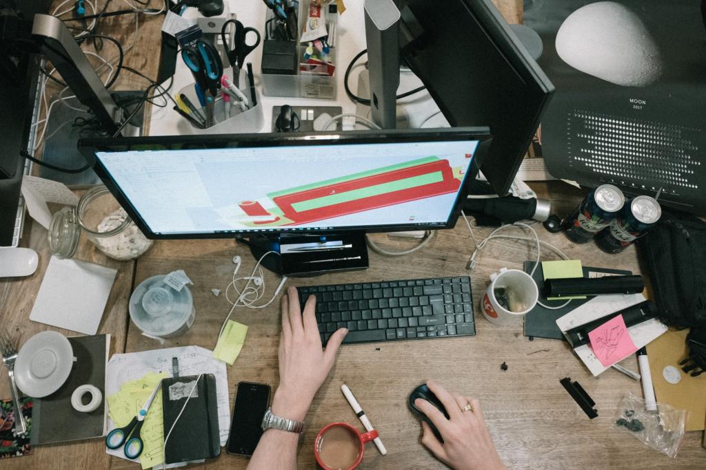 Work in an uncluttered environment - man working at messy desk