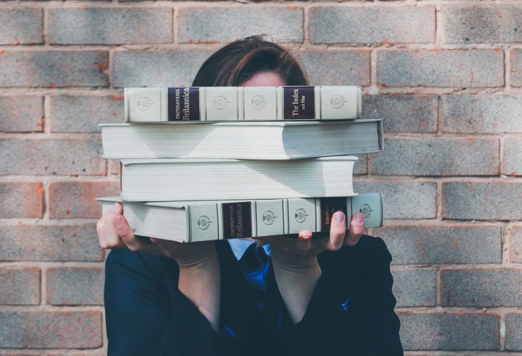 Woman behind stack of hard-back books