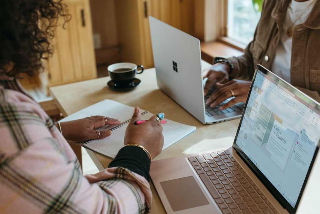 Woman studying in front of computer with a friend