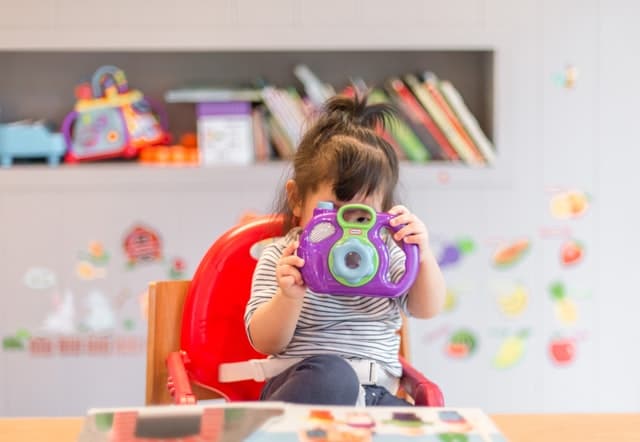 A little girl using a toy camera